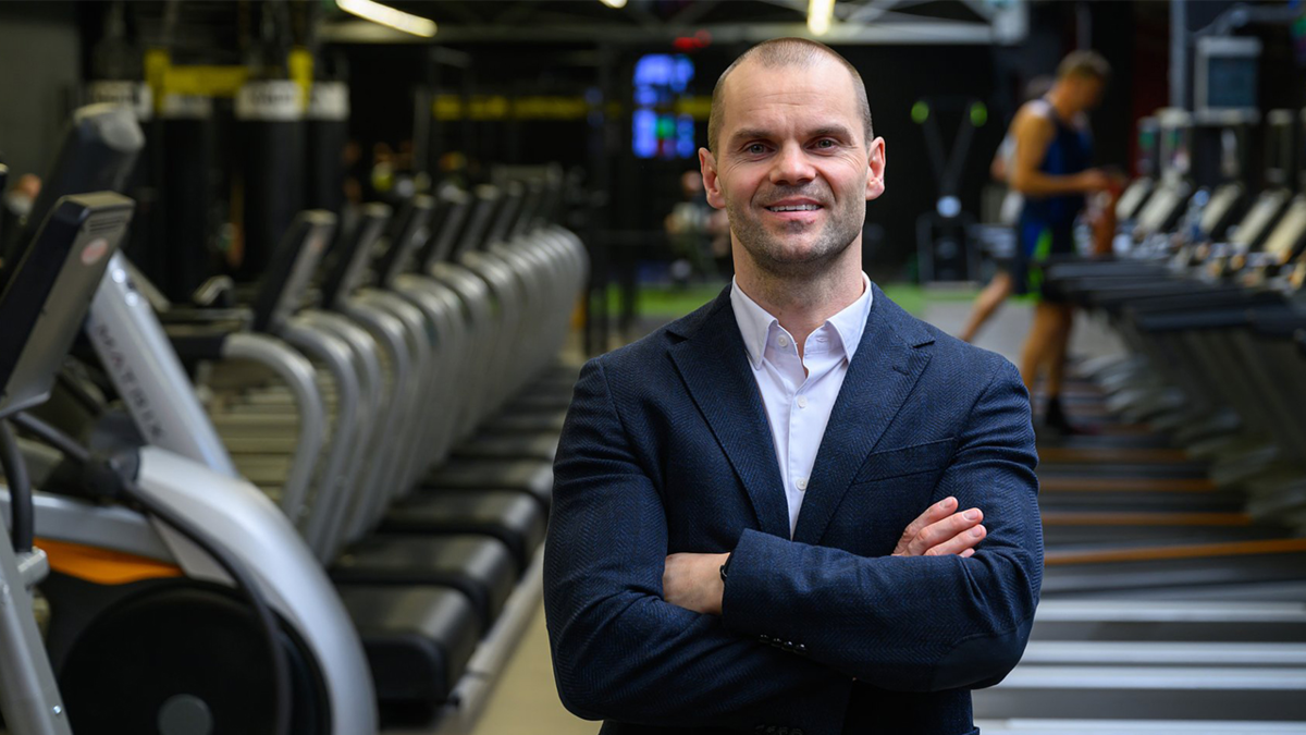 Łukasz Dojka na tle sprzętu fitness